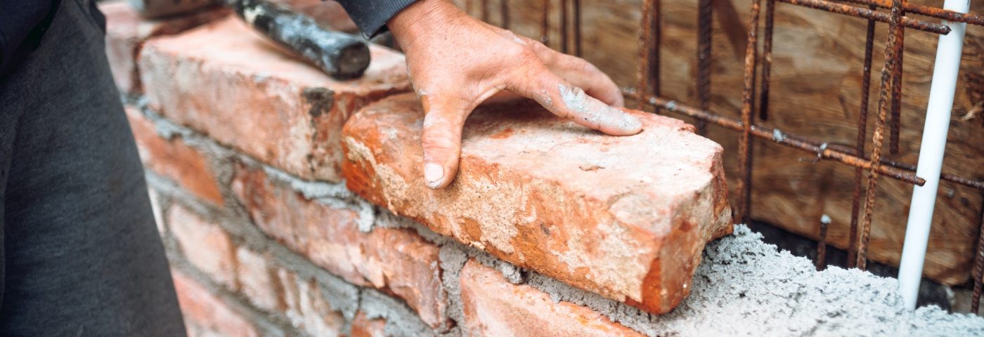 bricklayer-worker-installing-brick-masonry-on-exterior-wall-with-hands-and-tools.jpg